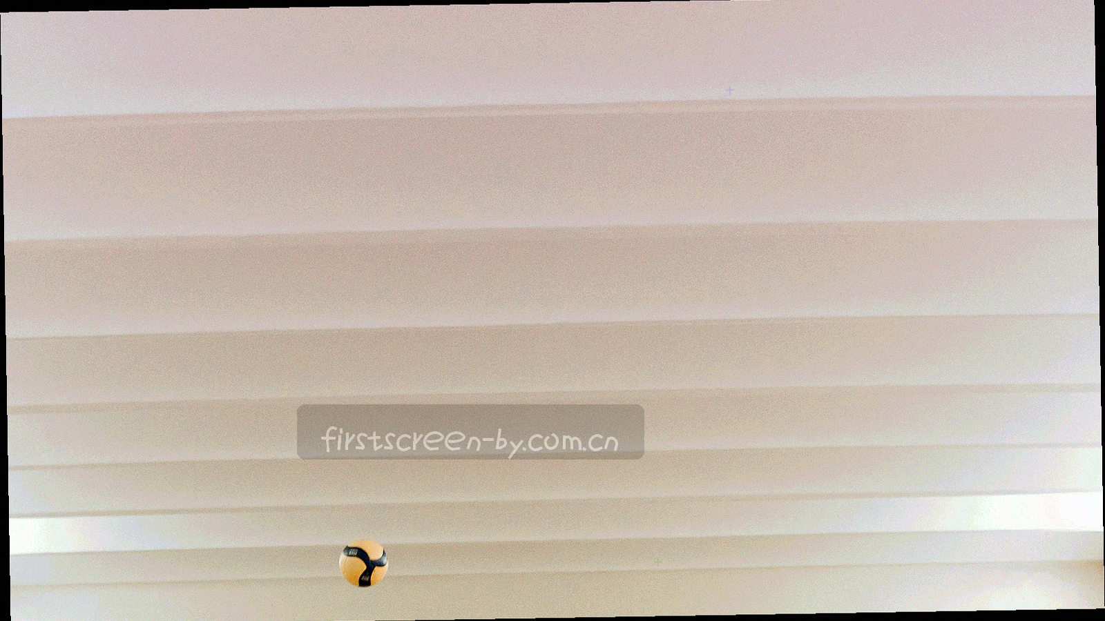 夜灯下的看台人群，广角低机位仰拍，围巾与灯光形成橙红与墨绿对比